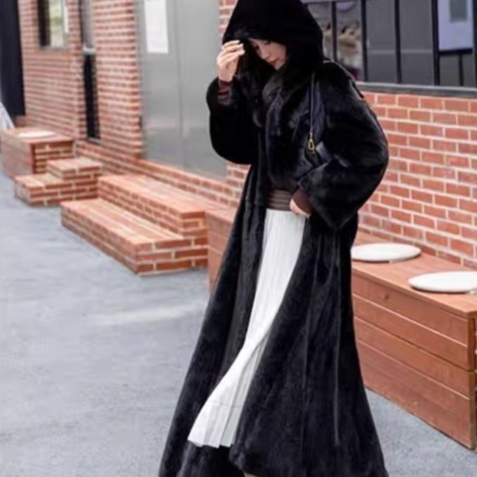 Long women's coat made of faux fur with hood