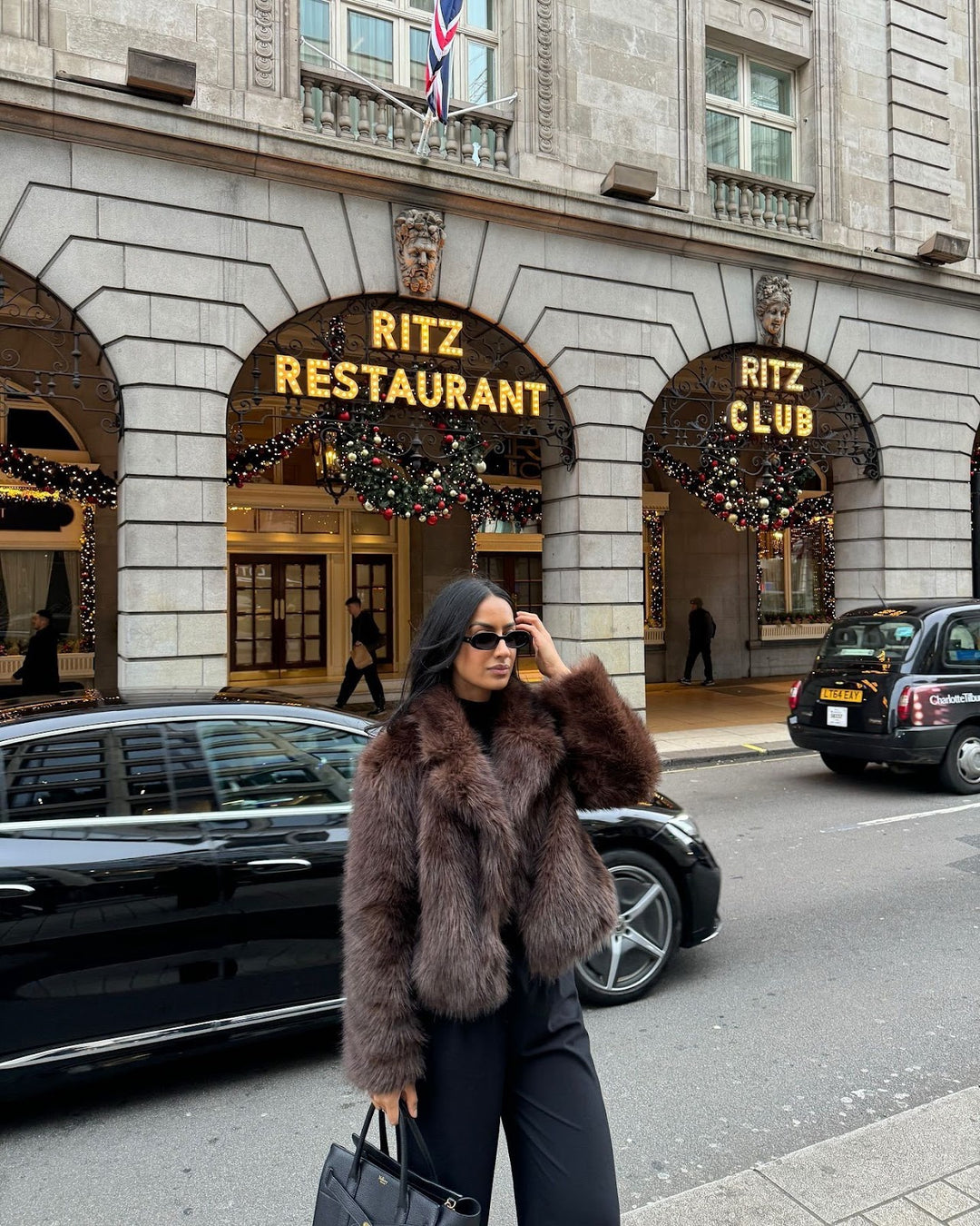 Fashionable women's faux fur coat in coffee brown
