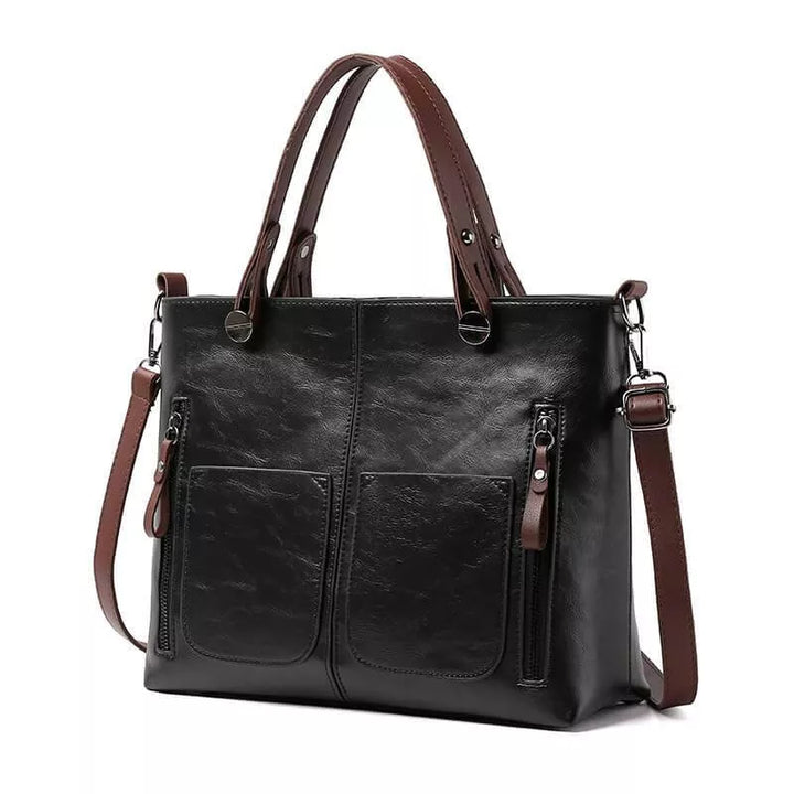 Schwarze Ledertasche mit braunem Riemen auf weißem Hintergrund