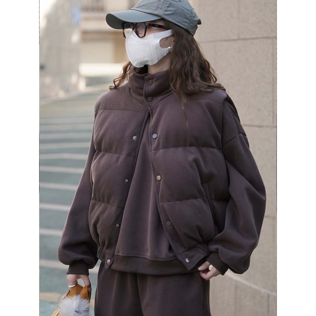 Women short cut quilted jacket with stand collar, snap button closure and elastic hem.