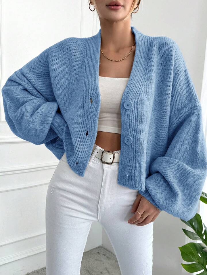 Women's oversized knitted cardigan with voluminous sleeves and chic button details