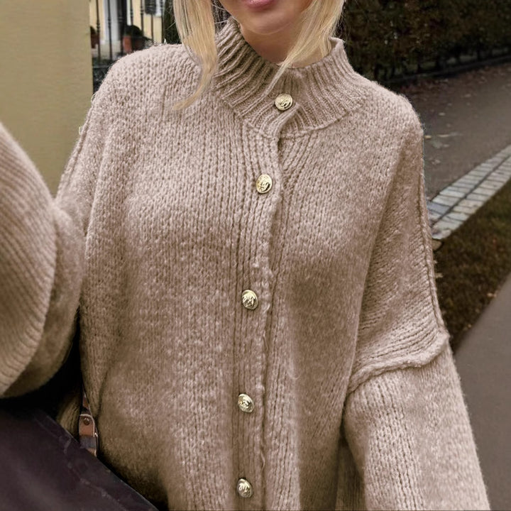 Women’s oversized knit cardigan made of chunky knit with ribbed round neck, dropped shoulders, and wooden button placket.