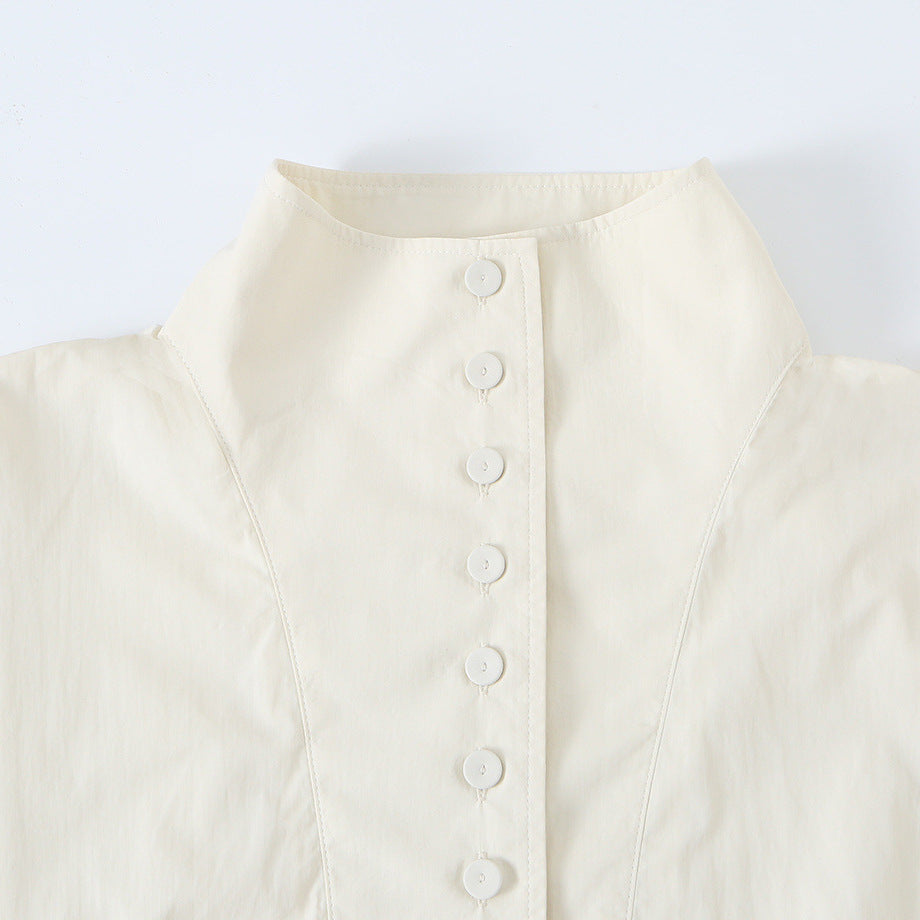 Women's cropped blouson jacket with stand-up collar, continuous decorative button placket and elastic hem.