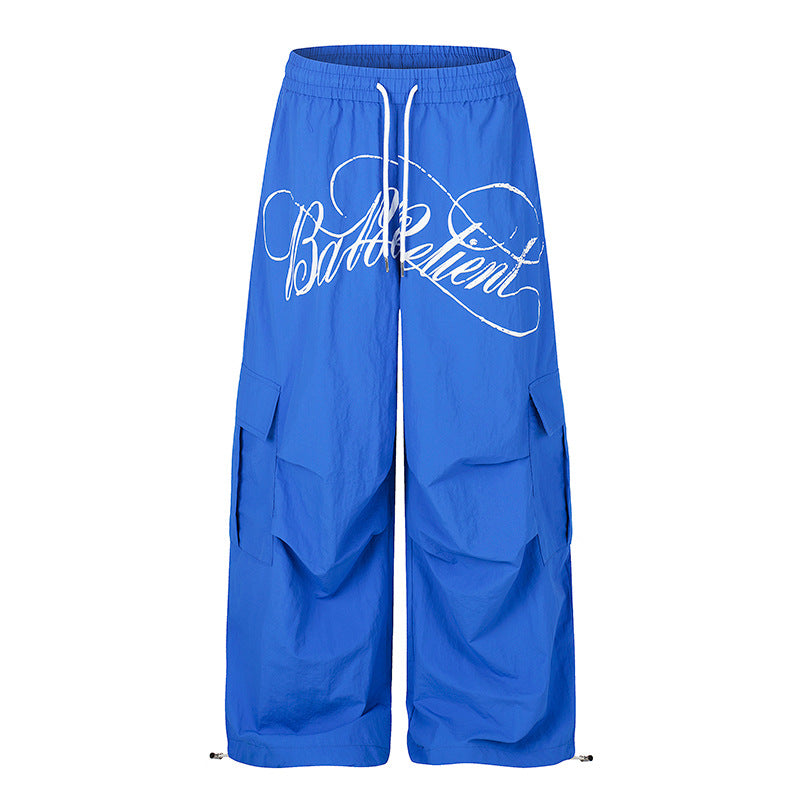 Women's wide palazzo cargo pants with elastic drawstring waistband, large flap pockets, and statement writing print Amarae