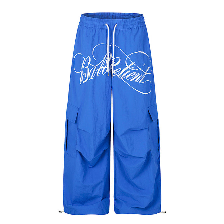 Women's wide palazzo cargo pants with elastic drawstring waistband, large flap pockets, and statement writing print Amarae