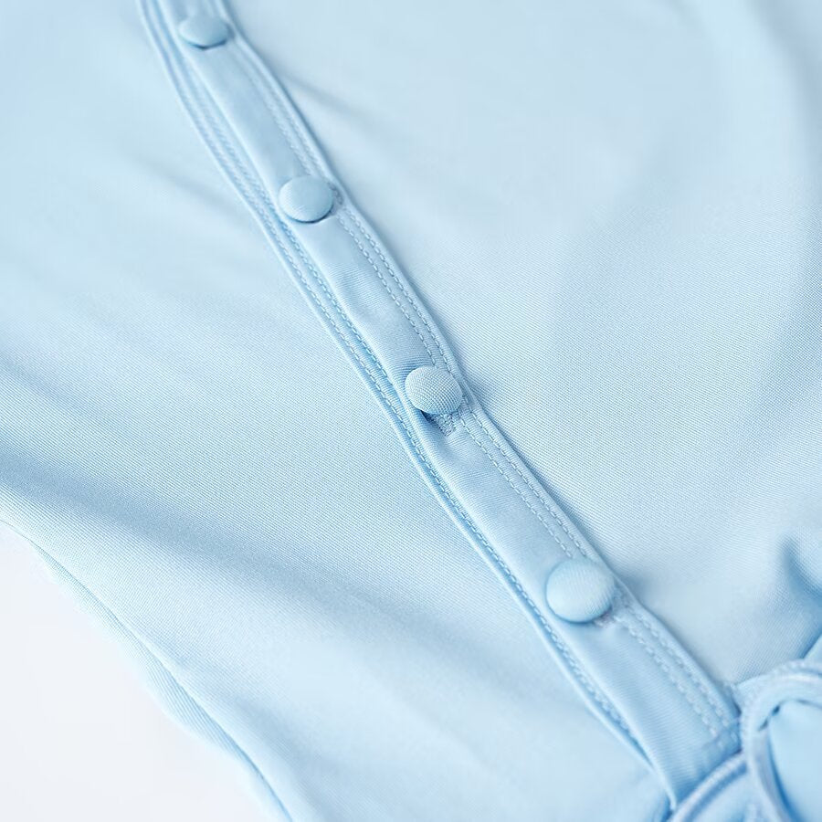 Women's wrap blouse with asymmetrical button placket, gathered hem, and trumpet sleeves Amarae