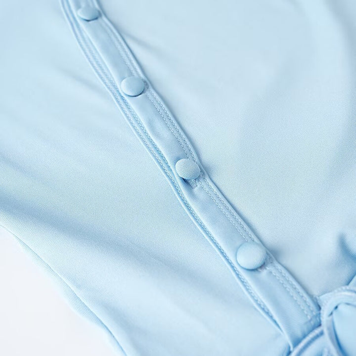 Women's wrap blouse with asymmetrical button placket, gathered hem, and trumpet sleeves Amarae