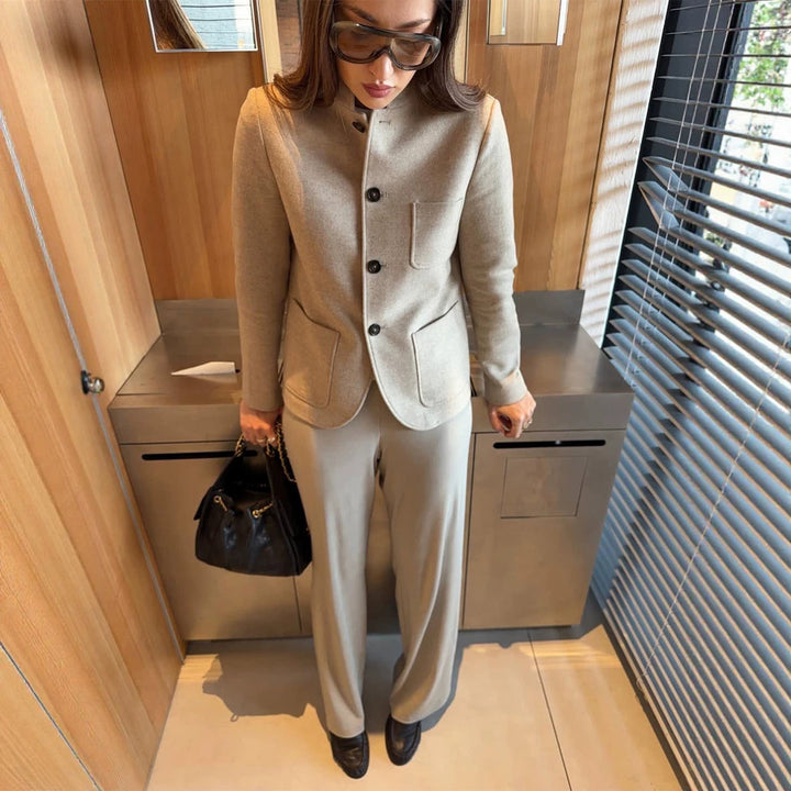 Women's tailored jacket blazer made of wool mix with stand-up collar, curved hem, and patch pockets.