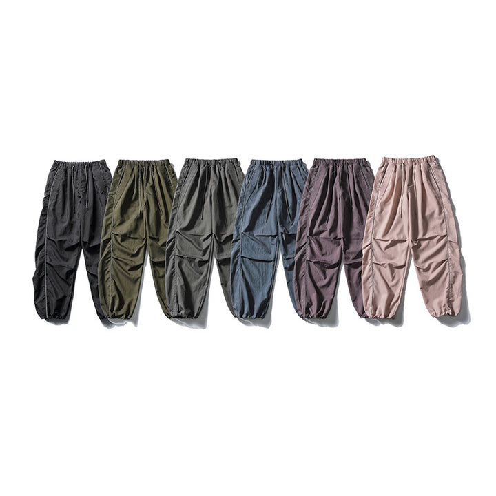 [Men] loose-fitting nylon jogger pants in utility style with drawstring waistband, contrast piping, and elastic ankle cuffs Amarae