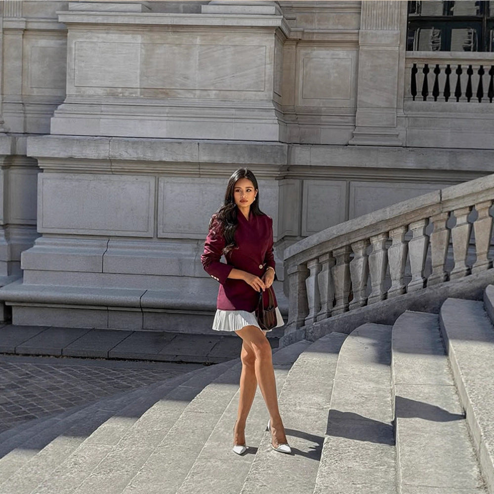 Women's tailored blazer with sculpted waist, asymmetric button detail, and extended hem.
