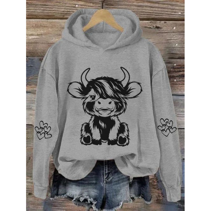 Women's hooded sweatshirt with charming cow motif and practical kangaroo pockets Lune London