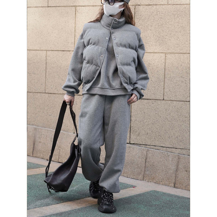 Women short cut quilted jacket with stand collar, snap button closure and elastic hem.