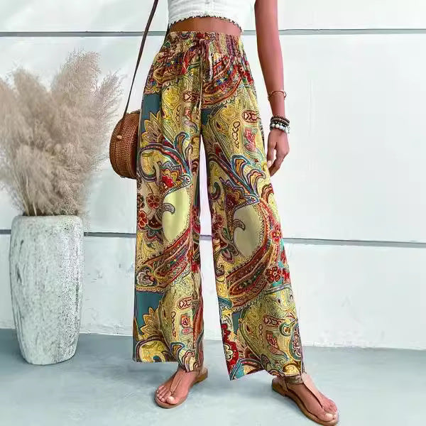 Wide palazzo pants for women with a colorful paisley pattern and an elastic waistband Lune London