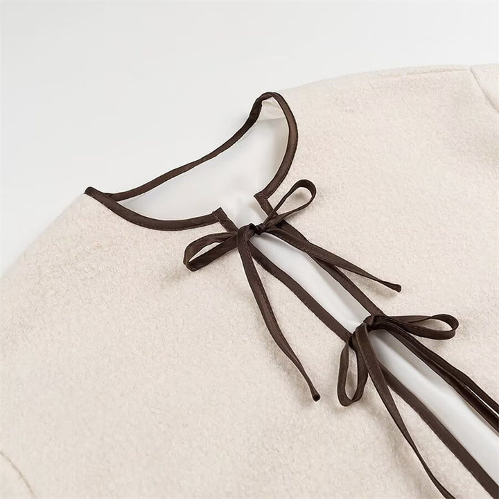 Fashion women's transitional jacket with decorative drawstring and side pockets.