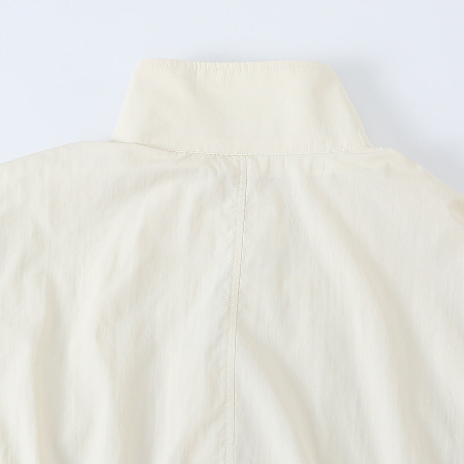 Women's cropped blouson jacket with stand-up collar, continuous decorative button placket and elastic hem.
