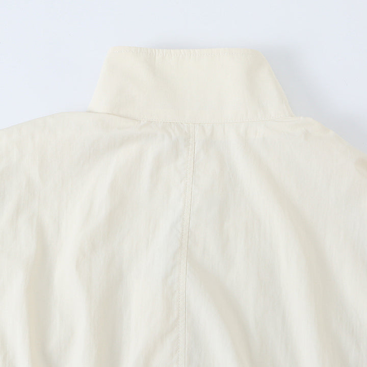 Women's cropped blouson jacket with stand-up collar, continuous decorative button placket and elastic hem.