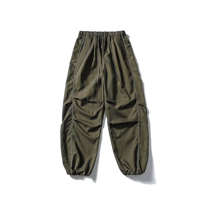 [Men] loose-fitting nylon jogger pants in utility style with drawstring waistband, contrast piping, and elastic ankle cuffs Amarae