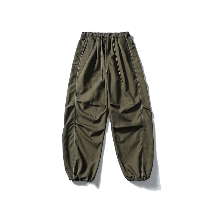 [Men] loose-fitting nylon jogger pants in utility style with drawstring waistband, contrast piping, and elastic ankle cuffs Amarae