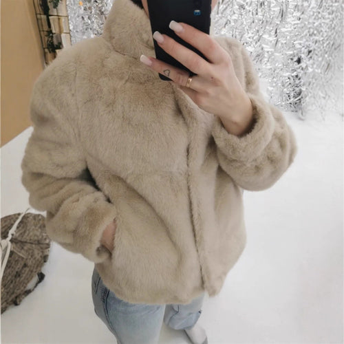 Fleece jacket for women with stand-up collar and side pockets with openings.