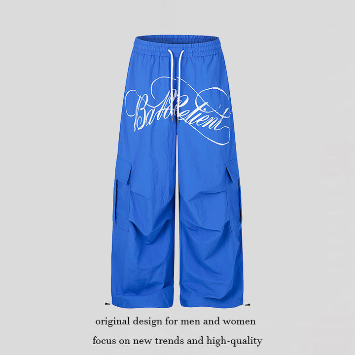 Women's wide palazzo cargo pants with elastic drawstring waistband, large flap pockets, and statement writing print Amarae