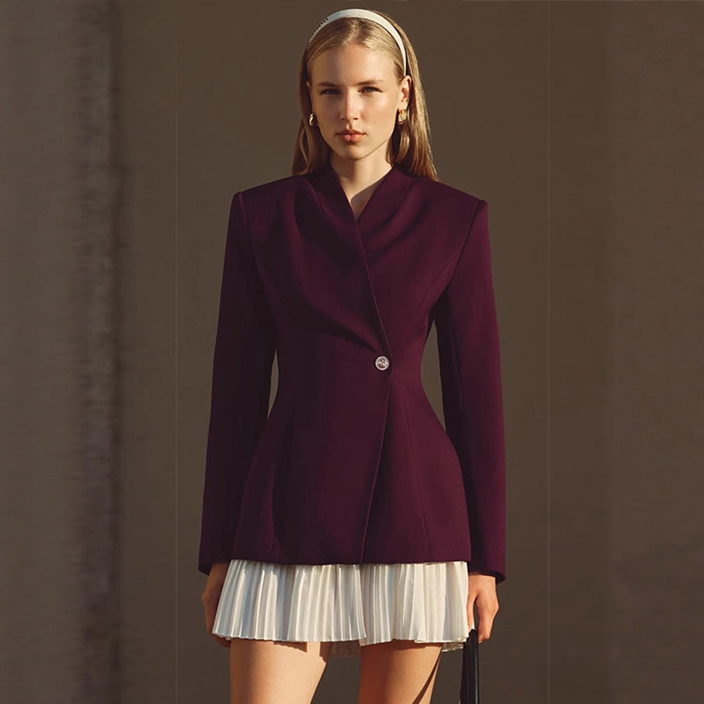 Women's tailored blazer with sculpted waist, asymmetric button detail, and extended hem.