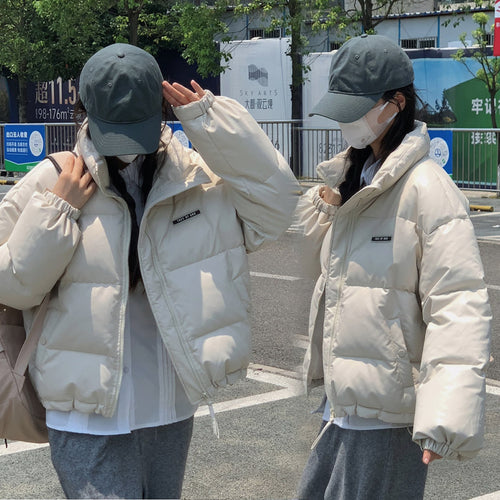 Trendy winter jacket for women with a high collar and zippered side pockets.