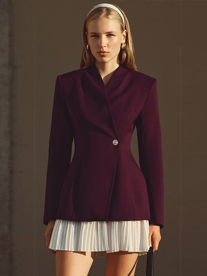 Women's tailored blazer with sculpted waist, asymmetric button detail, and extended hem.
