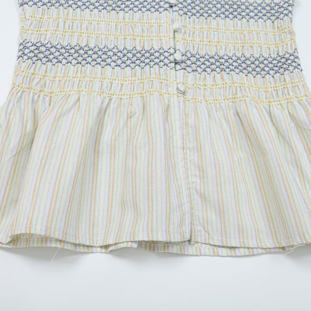 Women's gathered sleeveless top with smocked bodice, button placket, and flared hem Amarae