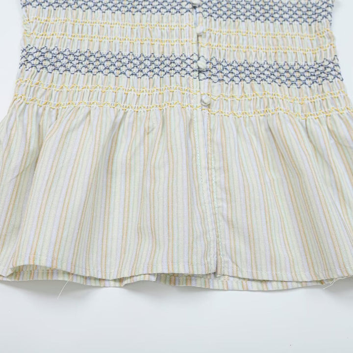 Women's gathered sleeveless top with smocked bodice, button placket, and flared hem Amarae