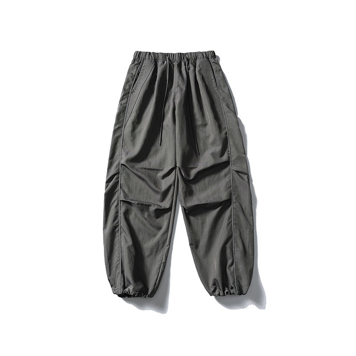 [Men] loose-fitting nylon jogger pants in utility style with drawstring waistband, contrast piping, and elastic ankle cuffs Amarae