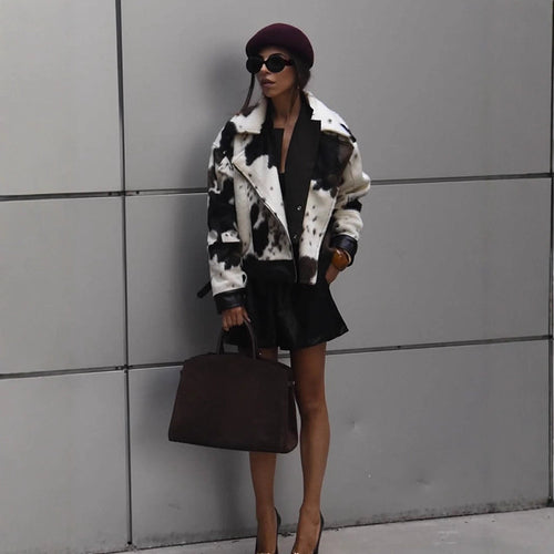 Women short padded biker jacket made of faux fur in cow print with contrast leather trim Amarae