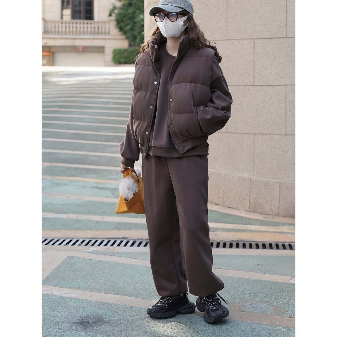 Women short cut quilted jacket with stand collar, snap button closure and elastic hem.